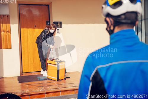 Image of Contacless delivery service during quarantine. Man delivers food and shopping bags during isolation