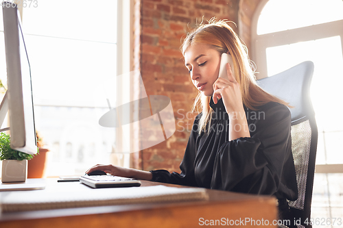 Image of Caucasian young woman in business attire working in office