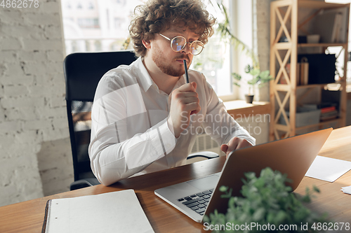 Image of Caucasian young man in business attire working in office, job, online studying