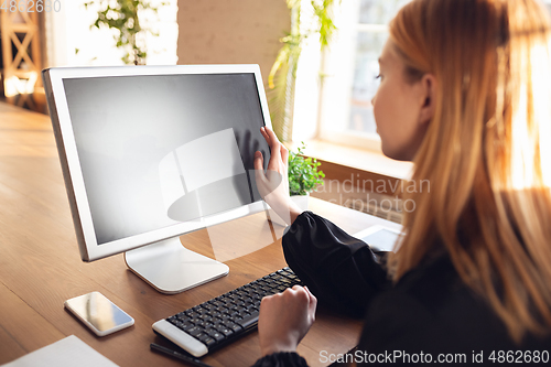 Image of Caucasian young woman in business attire working in office