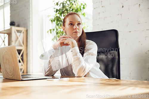 Image of Caucasian young woman in business attire working in office