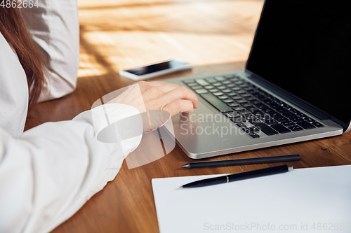 Image of Caucasian young woman in business attire working in office