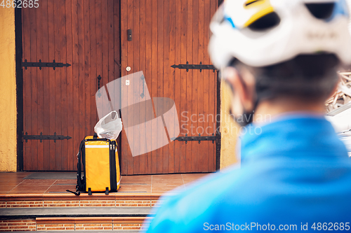 Image of Contacless delivery service during quarantine. Man delivers food and shopping bags during isolation