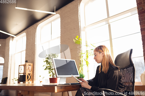 Image of Caucasian young woman in business attire working in office