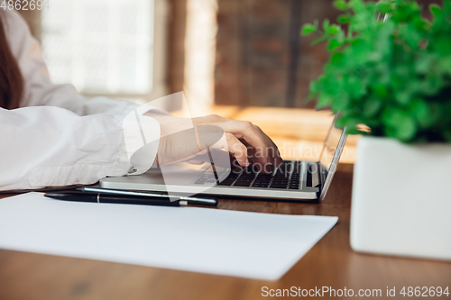 Image of Caucasian young woman in business attire working in office