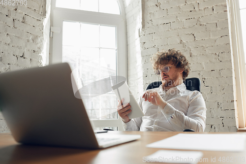 Image of Caucasian young man in business attire working in office, job, online studying