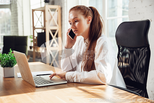 Image of Caucasian young woman in business attire working in office