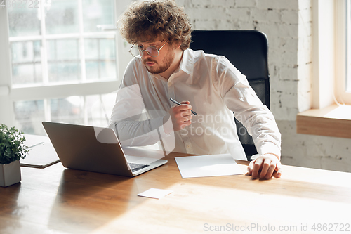 Image of Caucasian young man in business attire working in office, job, online studying