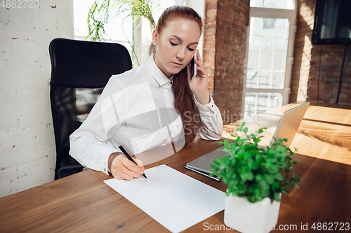 Image of Caucasian young woman in business attire working in office