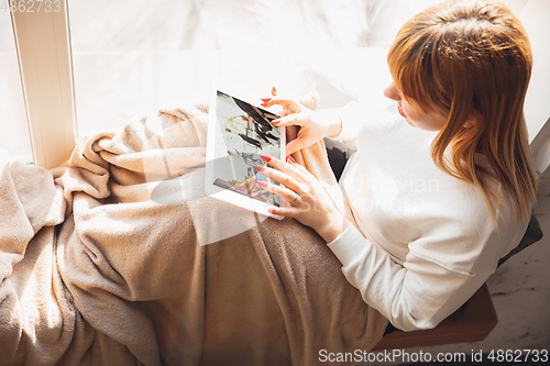 Image of Young woman using gadgets to watch cinema, photos, online courses, taking selfie or vlog, online shopping