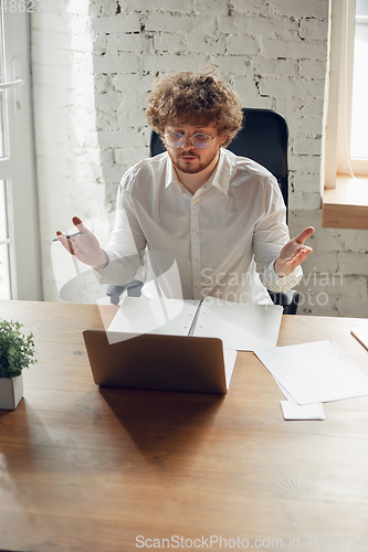 Image of Caucasian young man in business attire working in office, job, online studying