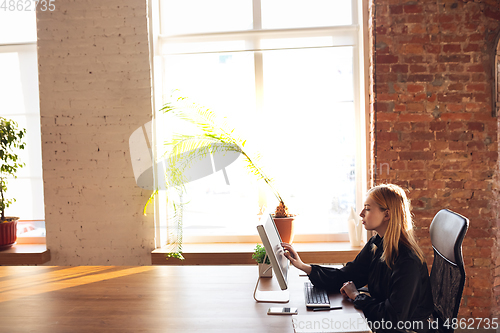 Image of Caucasian young woman in business attire working in office