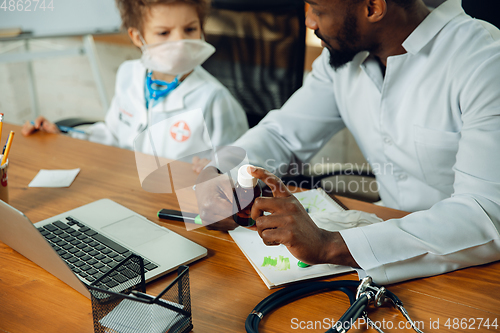 Image of Little caucasian boy as a doctor consulting for patient, working in cabinet, close up