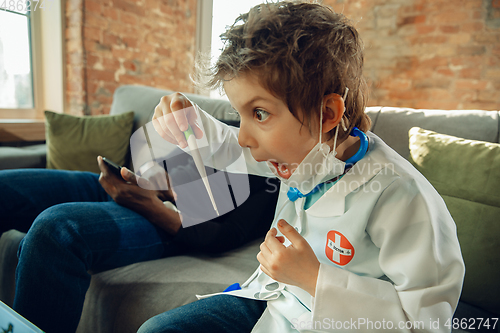 Image of Little caucasian boy as a doctor consulting for patient, working in cabinet, close up