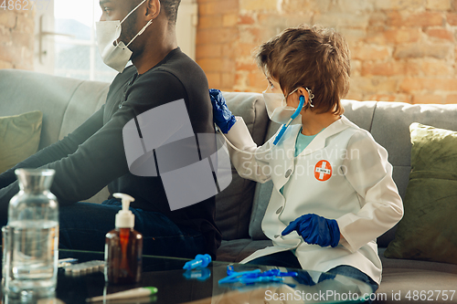 Image of Little caucasian boy as a doctor consulting for patient, working in cabinet, close up