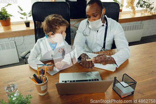 Image of Little caucasian boy as a doctor consulting for patient, working in cabinet, close up