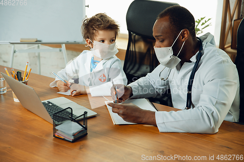 Image of Little caucasian boy as a doctor consulting for patient, working in cabinet, close up