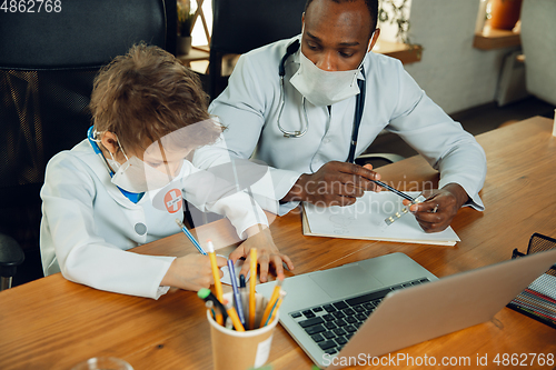 Image of Little caucasian boy as a doctor consulting for patient, working in cabinet, close up