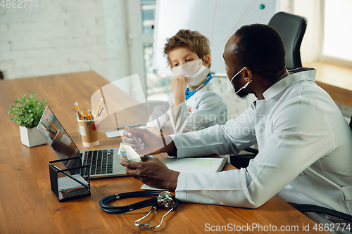 Image of Little caucasian boy as a doctor consulting for patient, working in cabinet, close up