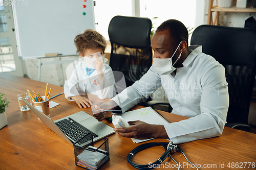 Image of Little caucasian boy as a doctor consulting for patient, working in cabinet, close up