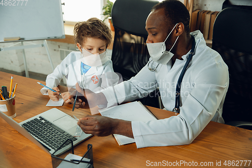 Image of Little caucasian boy as a doctor consulting for patient, working in cabinet, close up