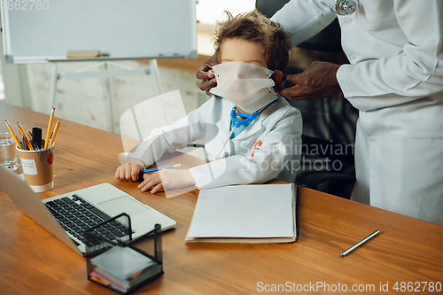 Image of Little caucasian boy as a doctor consulting for patient, working in cabinet, close up