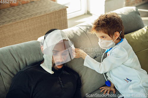 Image of Little caucasian boy as a doctor consulting for patient, working in cabinet, close up