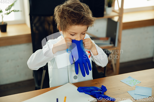 Image of Little caucasian boy as a doctor consulting for patient, working in cabinet, close up