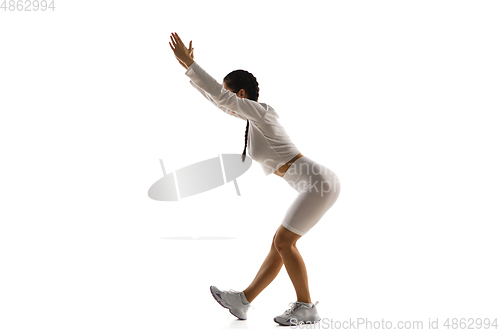 Image of Young caucasian female model in action, motion isolated on white background. Concept of sport, movement, energy and dynamic, healthy lifestyle. Training, practicing.