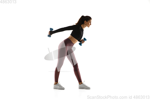 Image of Young caucasian female model in action, motion isolated on white background. Concept of sport, movement, energy and dynamic, healthy lifestyle. Training, practicing.