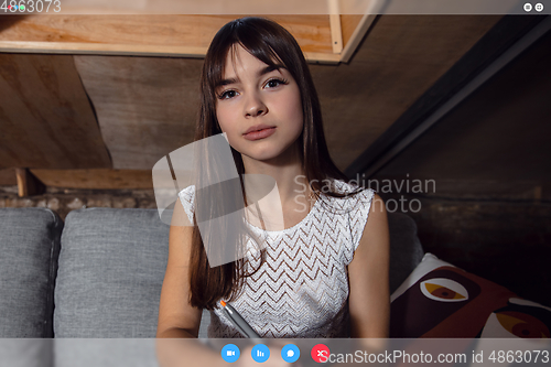 Image of Young woman talking, working in videoconference with co-workers at office or living room. Online business, education during quarantine.