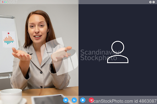 Image of Young woman talking, working in videoconference with co-workers at office or living room. Online business, education during quarantine.