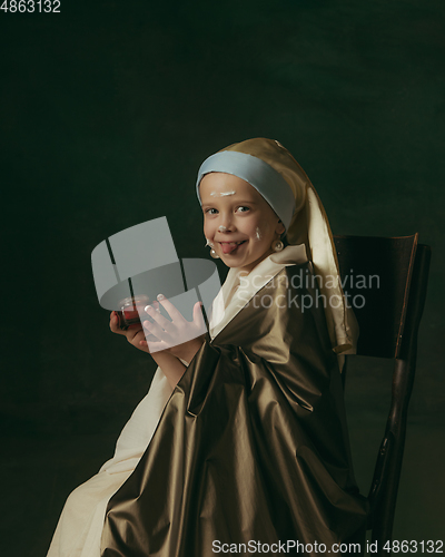 Image of Medieval little girl as a lady with a pearl earring on dark studio background. Concept of comparison of eras, childhood. Stylish creative design, art vision, new look of artwork.