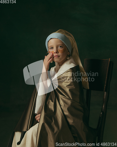 Image of Medieval little girl as a lady with a pearl earring on dark studio background. Concept of comparison of eras, childhood. Stylish creative design, art vision, new look of artwork.