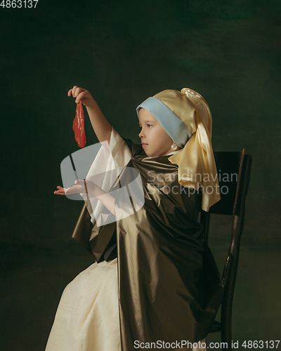 Image of Medieval little girl as a lady with a pearl earring on dark studio background. Concept of comparison of eras, childhood. Stylish creative design, art vision, new look of artwork.