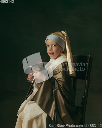 Image of Medieval little girl as a lady with a pearl earring on dark studio background. Concept of comparison of eras, childhood. Stylish creative design, art vision, new look of artwork.