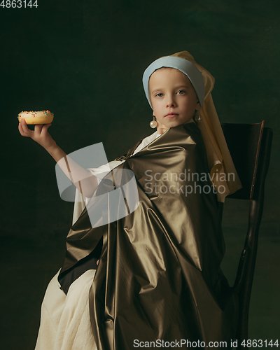 Image of Medieval little girl as a lady with a pearl earring on dark studio background. Concept of comparison of eras, childhood. Stylish creative design, art vision, new look of artwork.