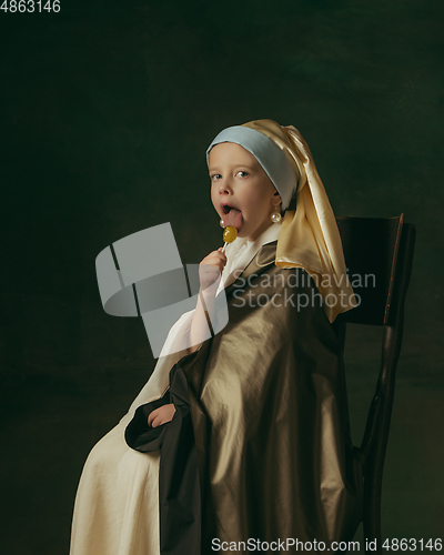 Image of Medieval little girl as a lady with a pearl earring on dark studio background. Concept of comparison of eras, childhood. Stylish creative design, art vision, new look of artwork.