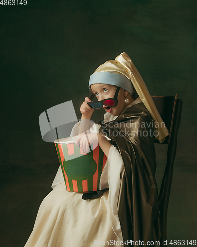 Image of Medieval little girl as a lady with a pearl earring on dark studio background. Concept of comparison of eras, childhood. Stylish creative design, art vision, new look of artwork.