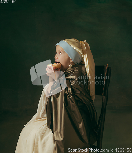 Image of Medieval little girl as a lady with a pearl earring on dark studio background. Concept of comparison of eras, childhood. Stylish creative design, art vision, new look of artwork.