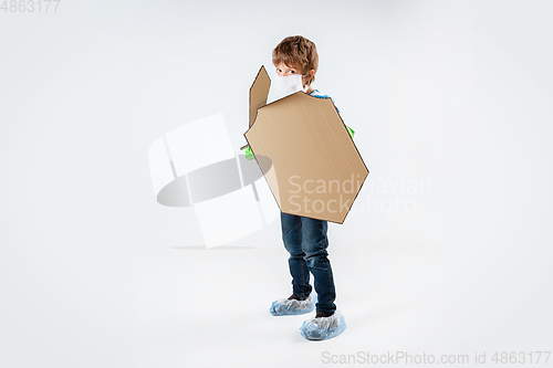 Image of Little caucasian boy as a warrior in fight with coronavirus pandemic, with a shield, a sword and a toilet paper bandoleer, attacking