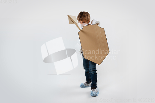 Image of Little caucasian boy as a warrior in fight with coronavirus pandemic, with a shield, a spear and a toilet paper bandoleer, attacking