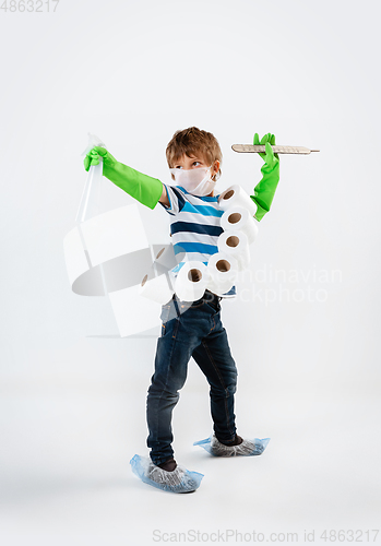 Image of Little caucasian boy as a warrior in fight with coronavirus pandemic, with a face mask, a thermometer, sanitizer and a toilet paper bandoleer