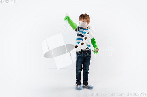 Image of Little caucasian boy as a warrior in fight with coronavirus pandemic, with a face mask, a thermometer, sanitizer and a toilet paper bandoleer