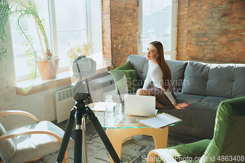 Image of Caucasian woman singing during online concert at home isolated and quarantined, impressive improvising, dancing
