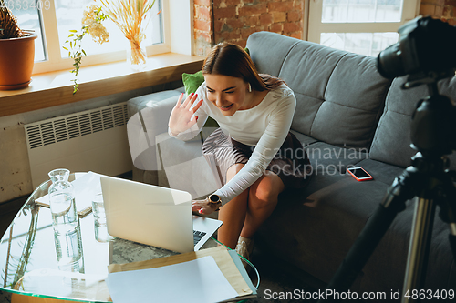 Image of Caucasian woman singing during online concert at home isolated and quarantined, tuning streaming