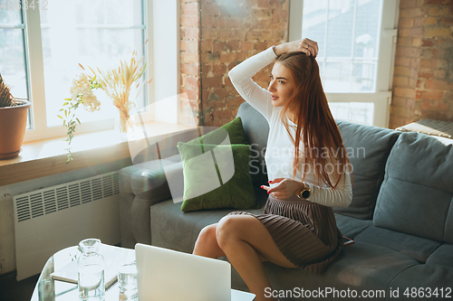 Image of Caucasian woman singing during online concert at home isolated and quarantined, impressive improvising, dancing