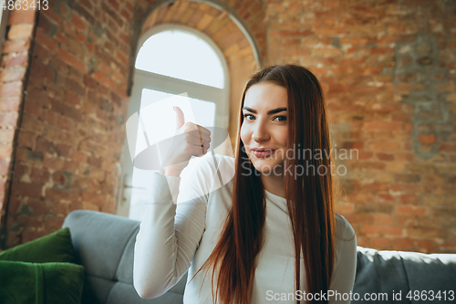 Image of Caucasian woman isolated on brick wall background at home quarantined, cheerful and happy