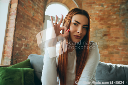 Image of Caucasian woman isolated on brick wall background at home quarantined, cheerful and happy