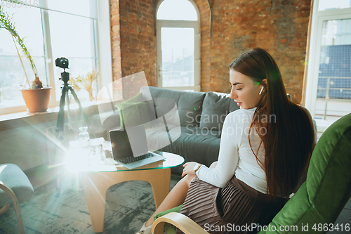 Image of Caucasian woman singing during online concert at home isolated and quarantined, impressive improvising, dancing